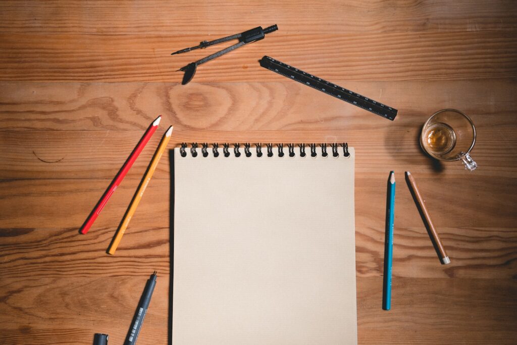 Wood table with paper sheet and drawing tools